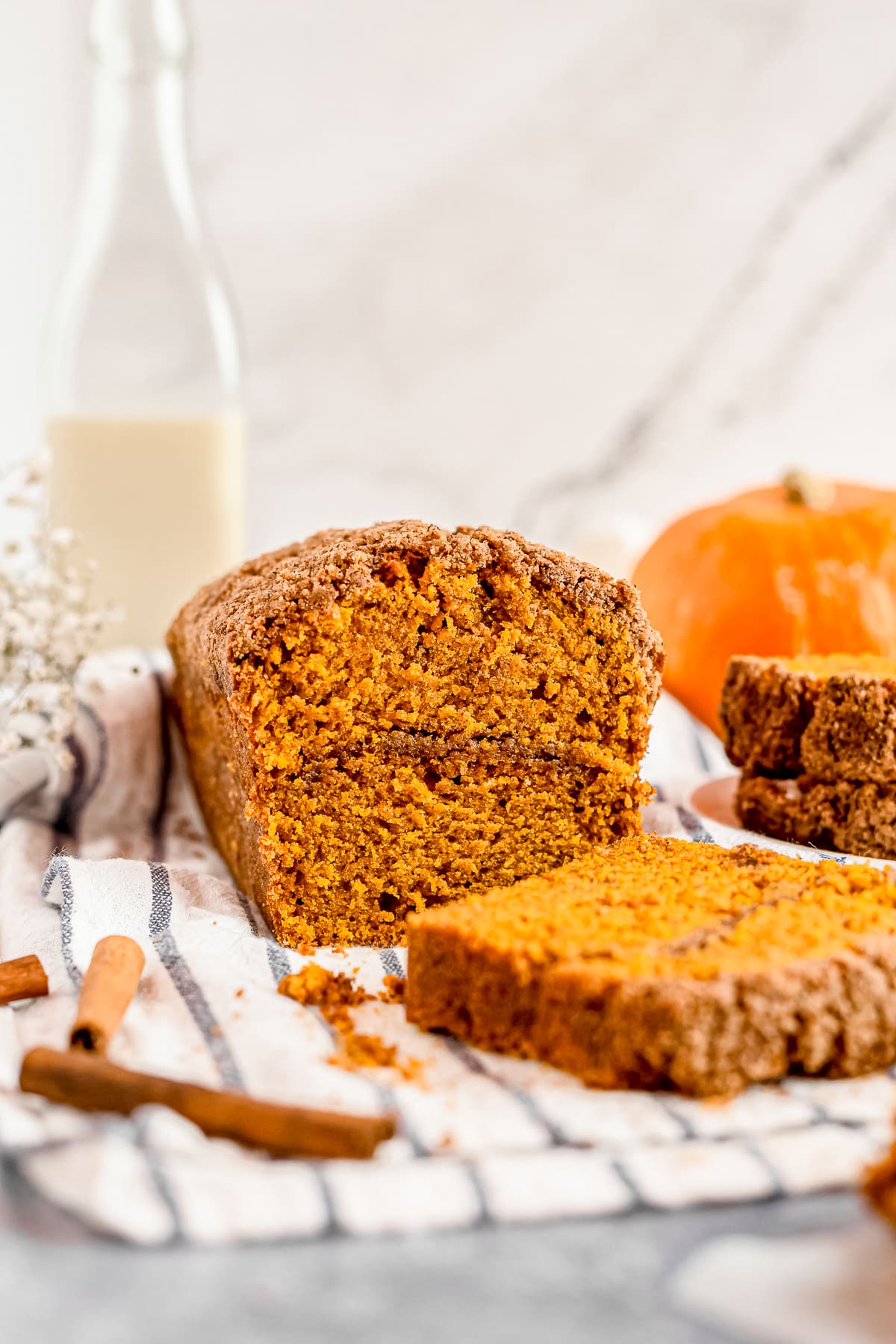 pumpkin bread with streusel topping sliced on a kitchen towel