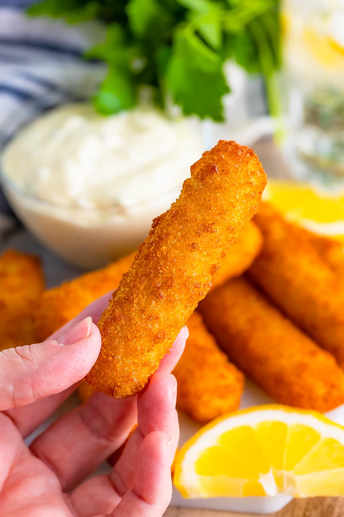 air fryer fish sticks held in air by a hand