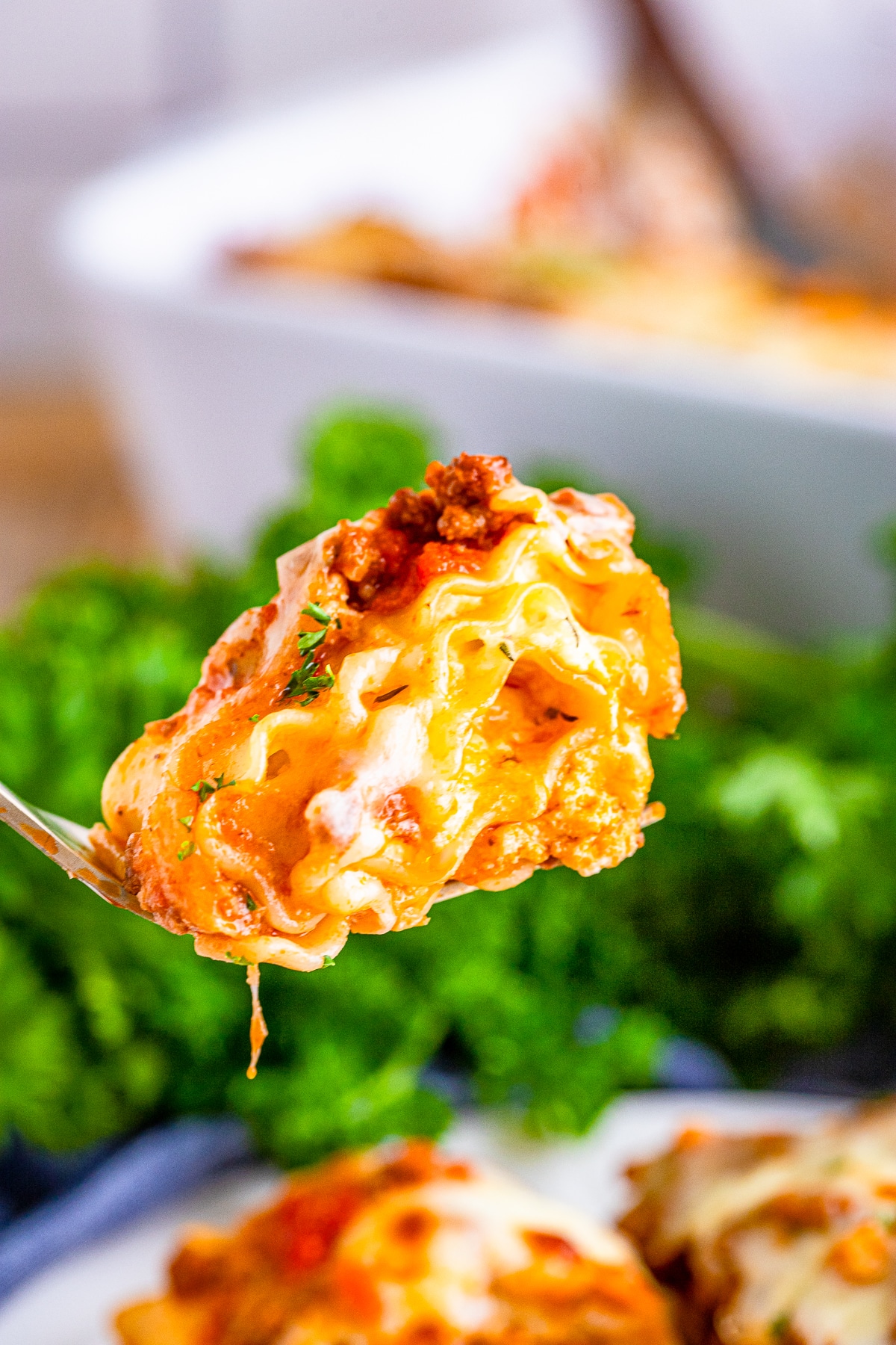 a fork holding up a bite of lasagna roll-ups in air