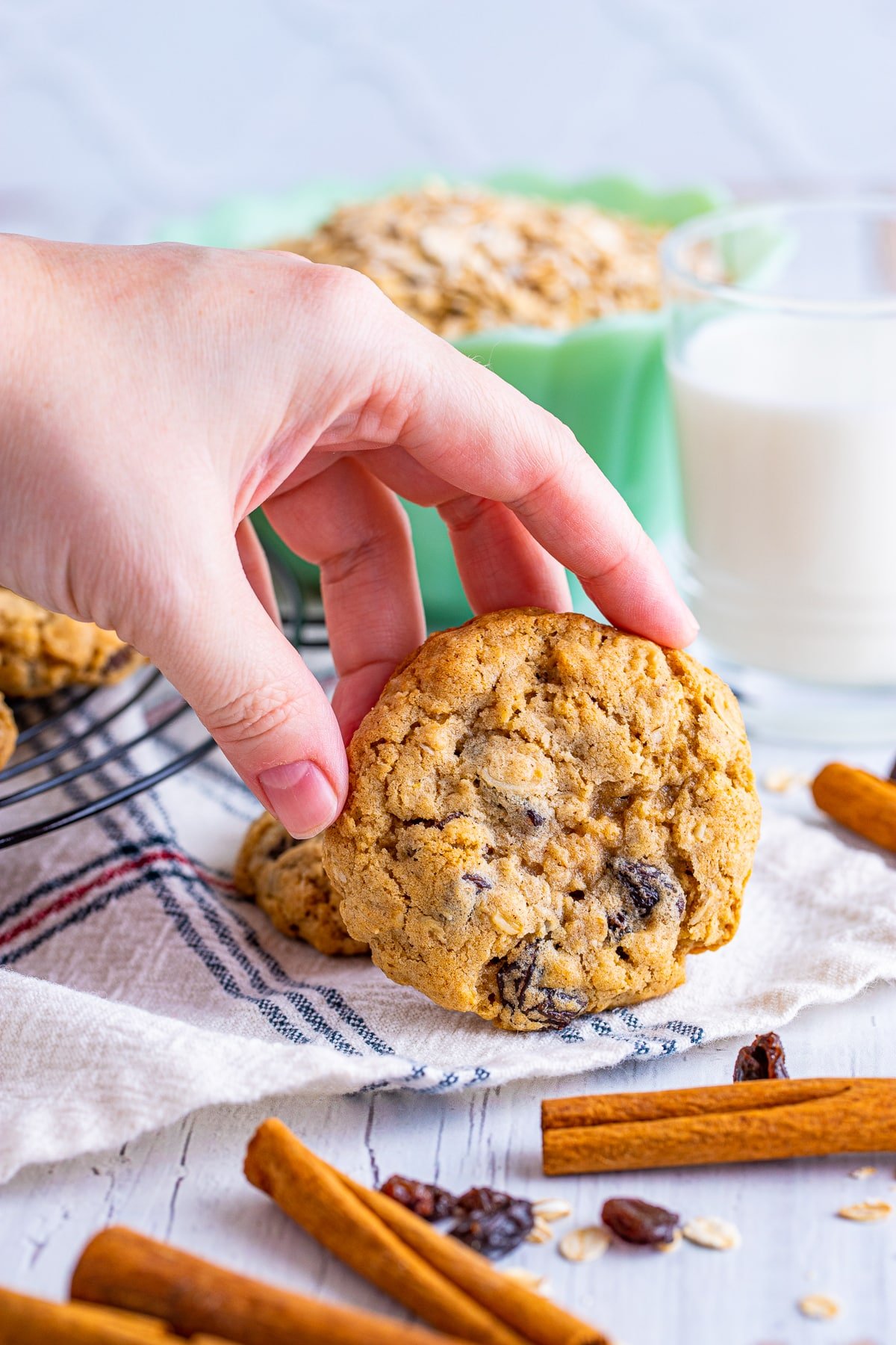 a hand grabbing an old fashioned oatmeal raisin cookie
