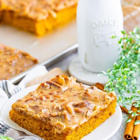 A square slice of Pumpkin Cake with bourbon praline frosting on a white plate.