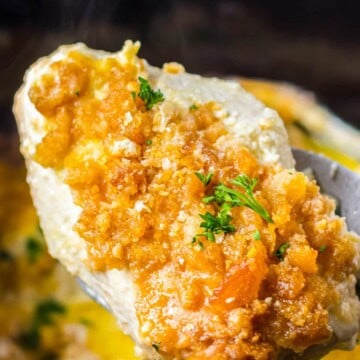 Creamy Ritz cracker chicken lifted from the slow cooker on a spoon.