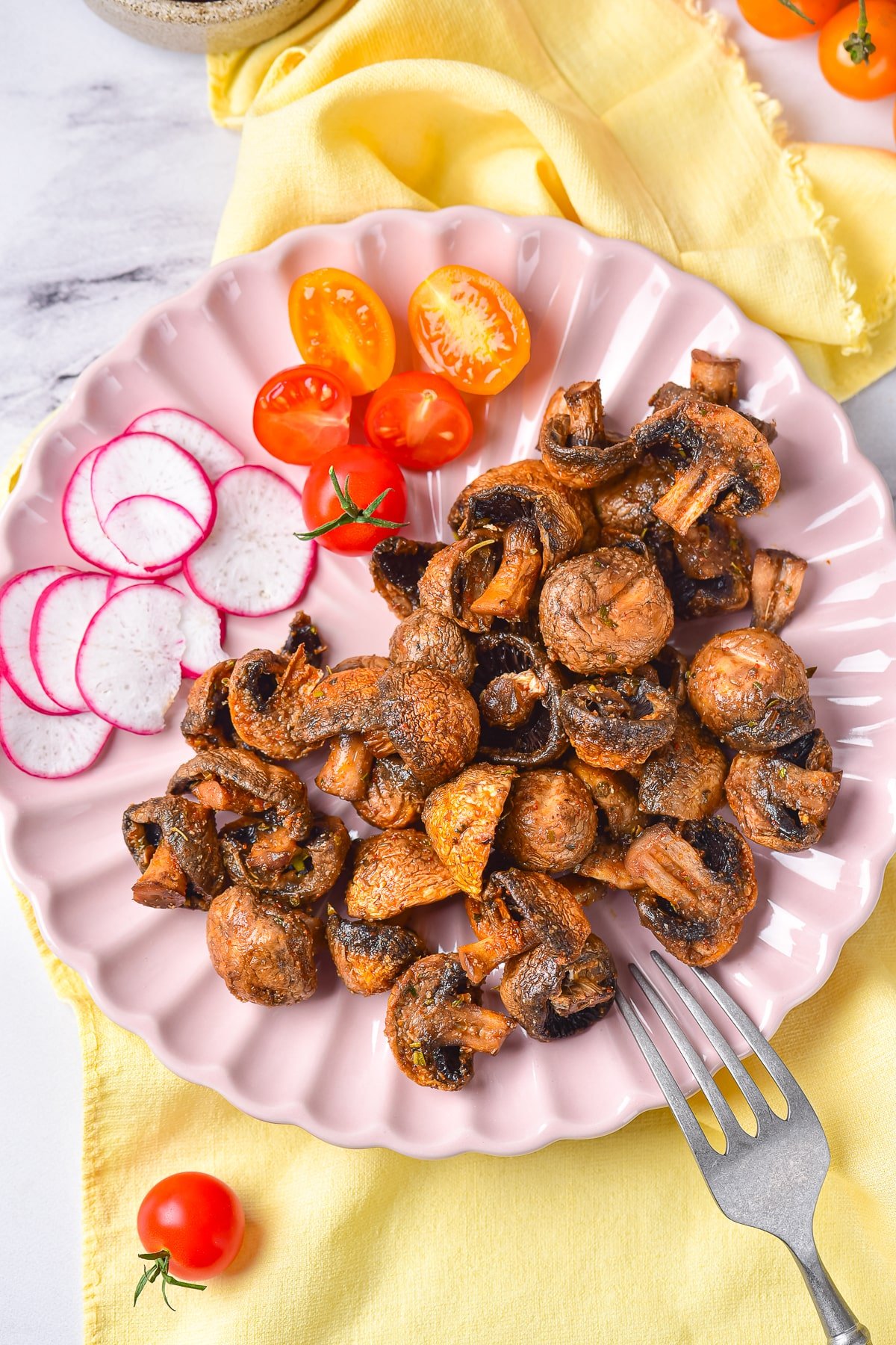 overhead image of air fryer mushrooms on a pink plate