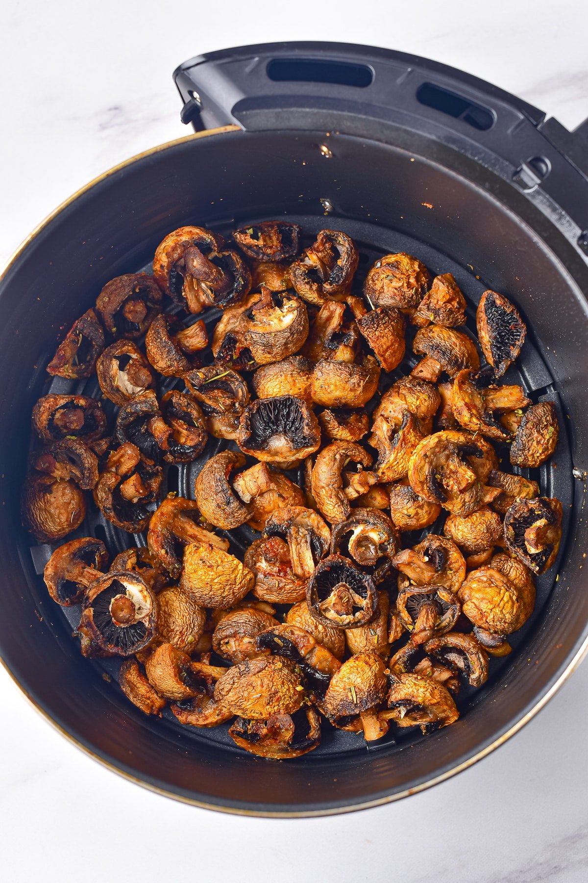 finished air fryer mushrooms in the air fryer basket