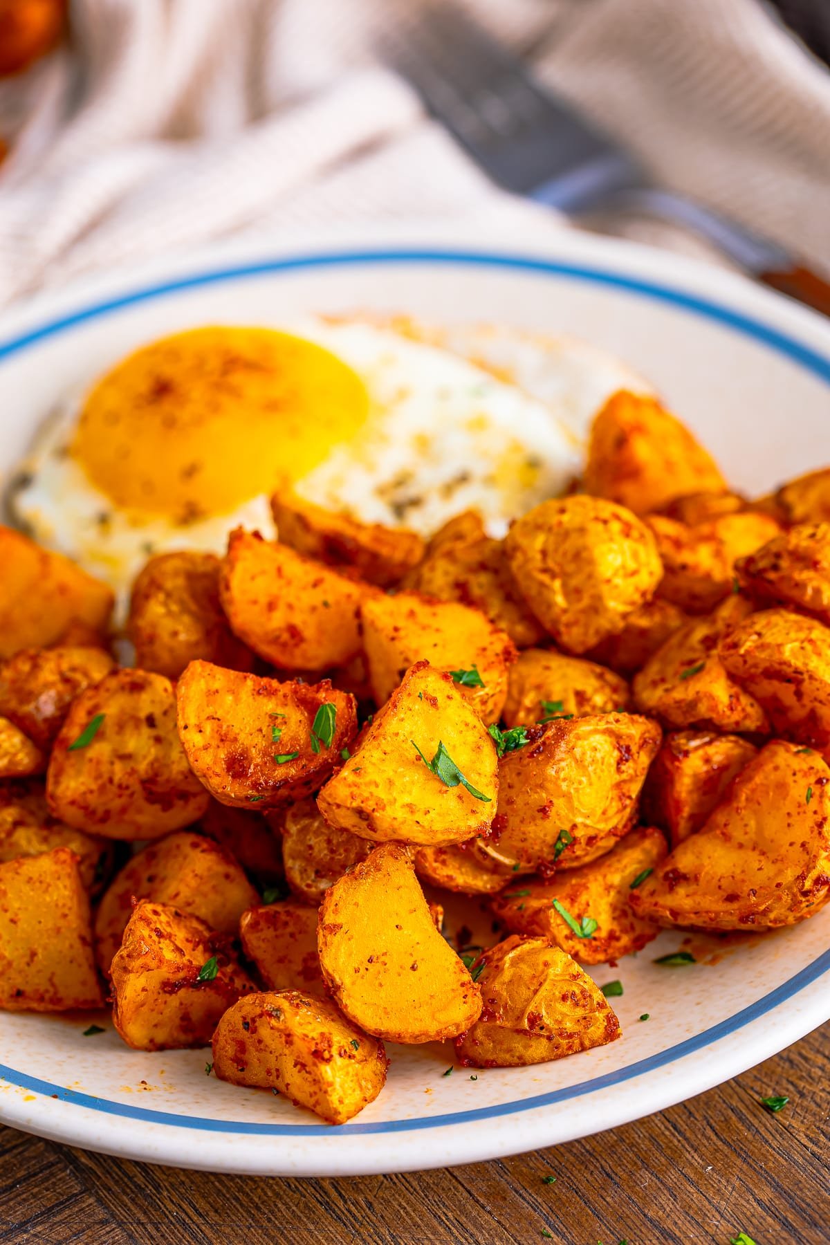 air fryer home fries on tan plate with egg
