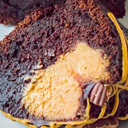 A slice of brownie cake showing the fudgy chocolate cake and creamy peanut butter filling inside.