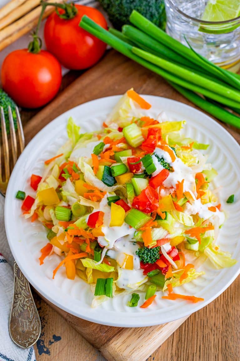 A plate of colorful chopped salad with shredded lettuce and finely diced vegetables.