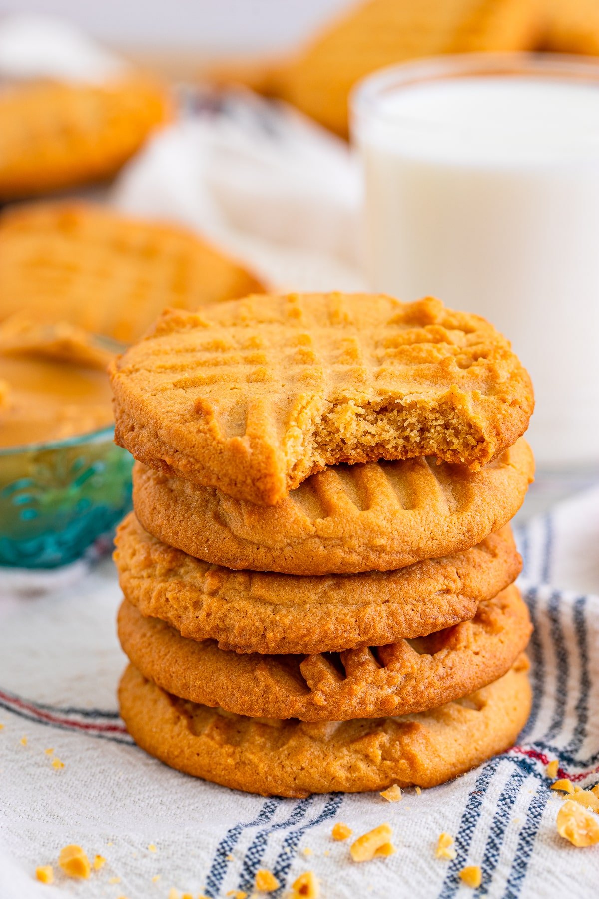 a stack of crispy peanut butter cookies with a bite taken out