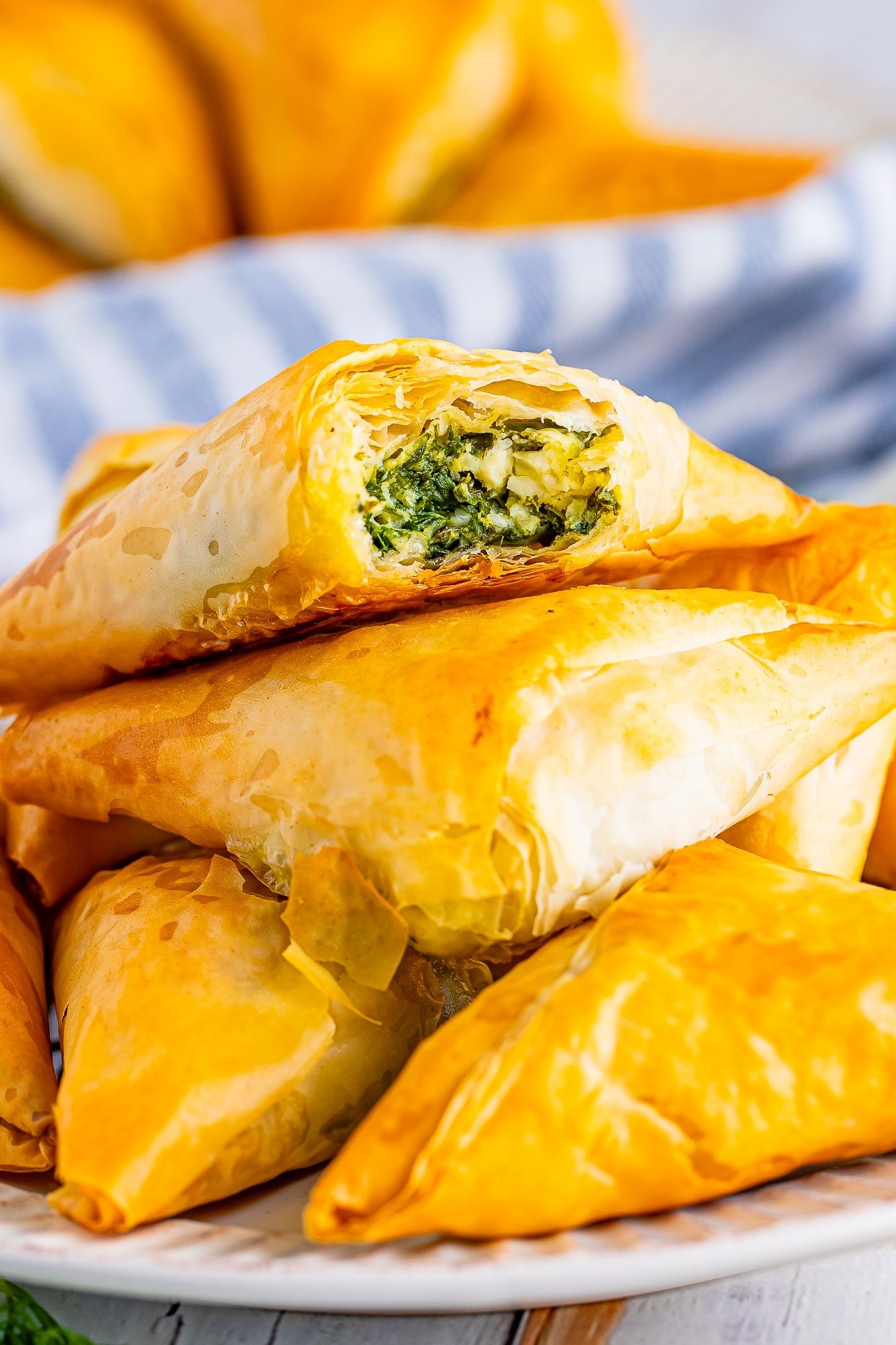 stacked spanakopita triangles with a bite taken out