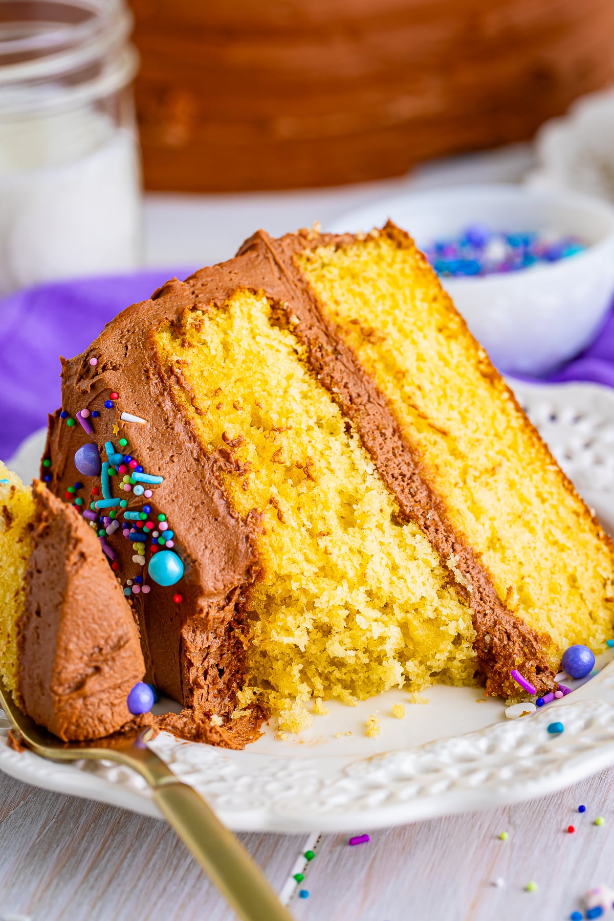yellow cake with chocolate frosting on a plate with a bite taken out