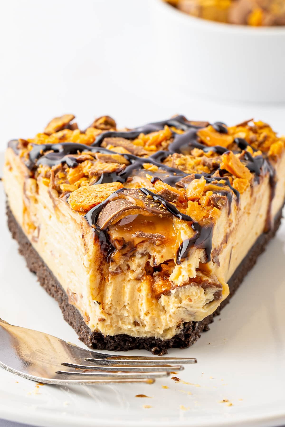 upclose image of butterfinger cheesecake with bite taken out