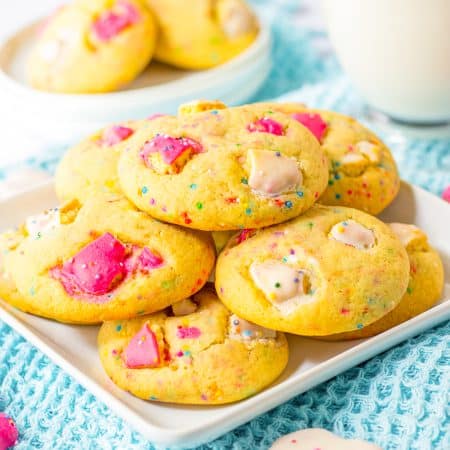 Thick and chewy animal cracker cookies on a white plate with a glass of milk.