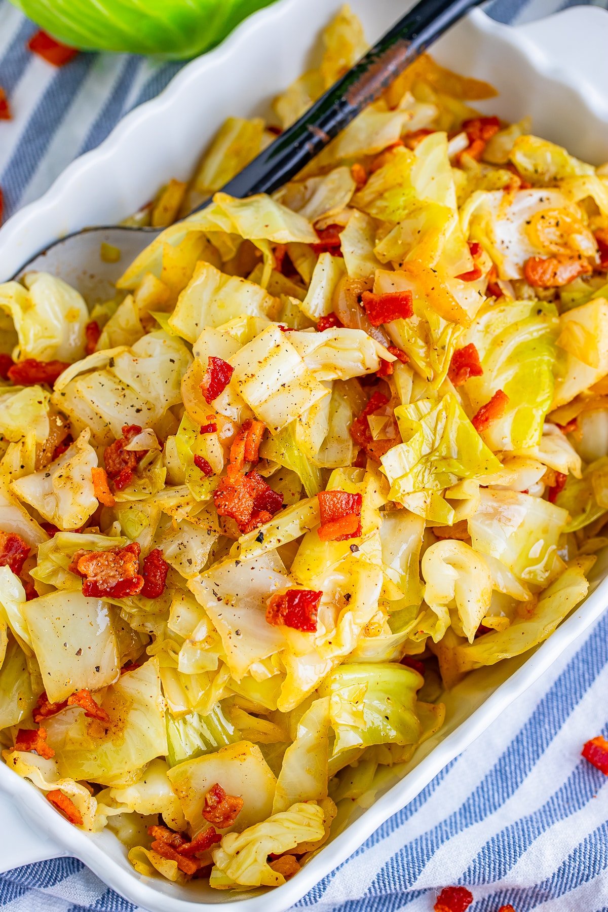 overhead image fried cabbage with bacon in white bowl