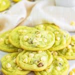 A stack of soft pistachio pudding cookies studded with white chocolate chips and pistachios.