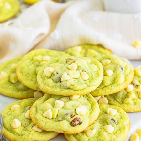 A stack of soft pistachio pudding cookies studded with white chocolate chips and pistachios.