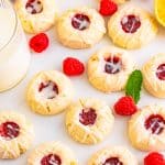 A plate of raspberry thumbprint cookies drizzled with lemon glaze.