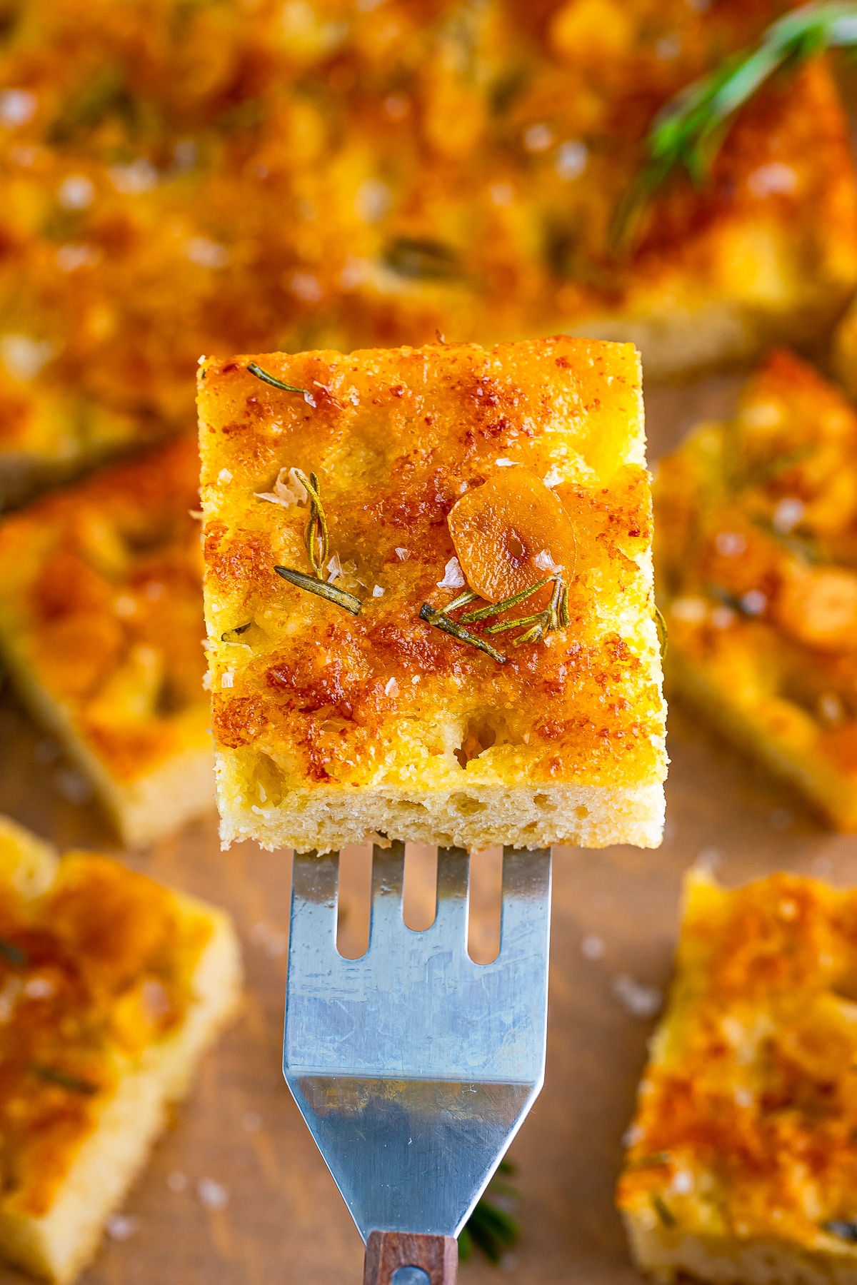 a spatula holding up a piece of easy focaccia recipe in air 