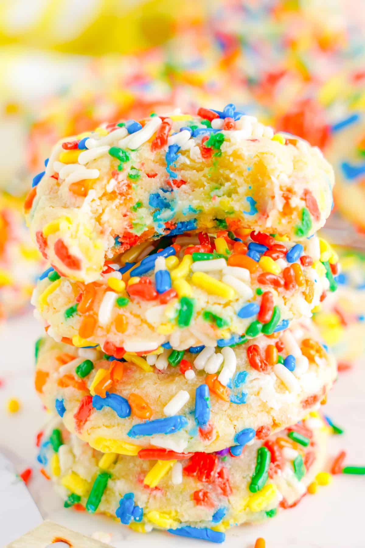 a stack of sprinkle cookies with a bite taken out