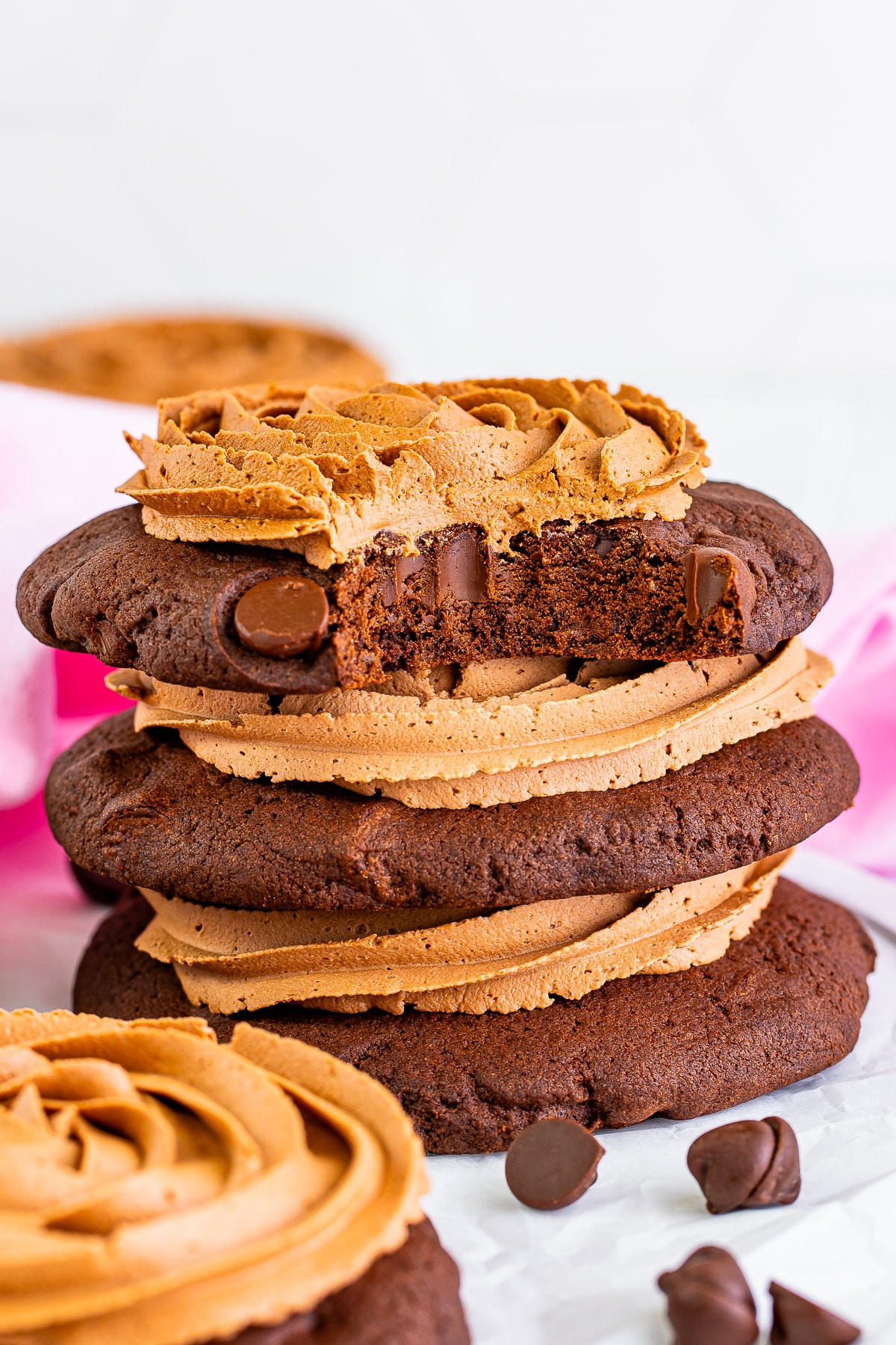 three triple chocolate cookies stacked with a bite taken out