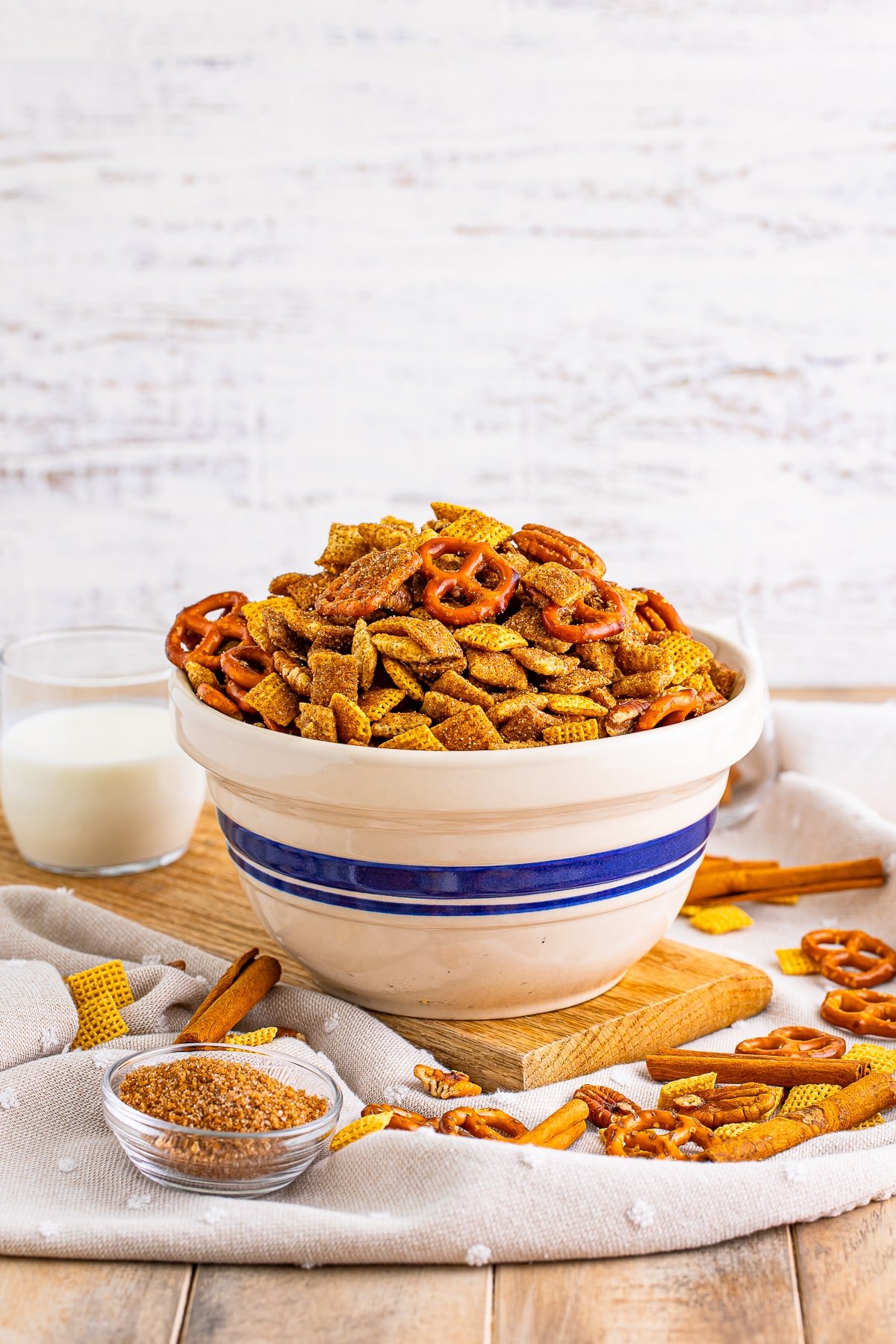 sweet chex mix recipe in a tan bowl on a wooden table top