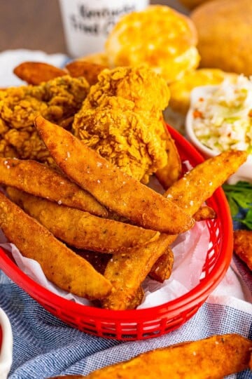 Copycat KFC potato wedges in a red basket with ketchup.