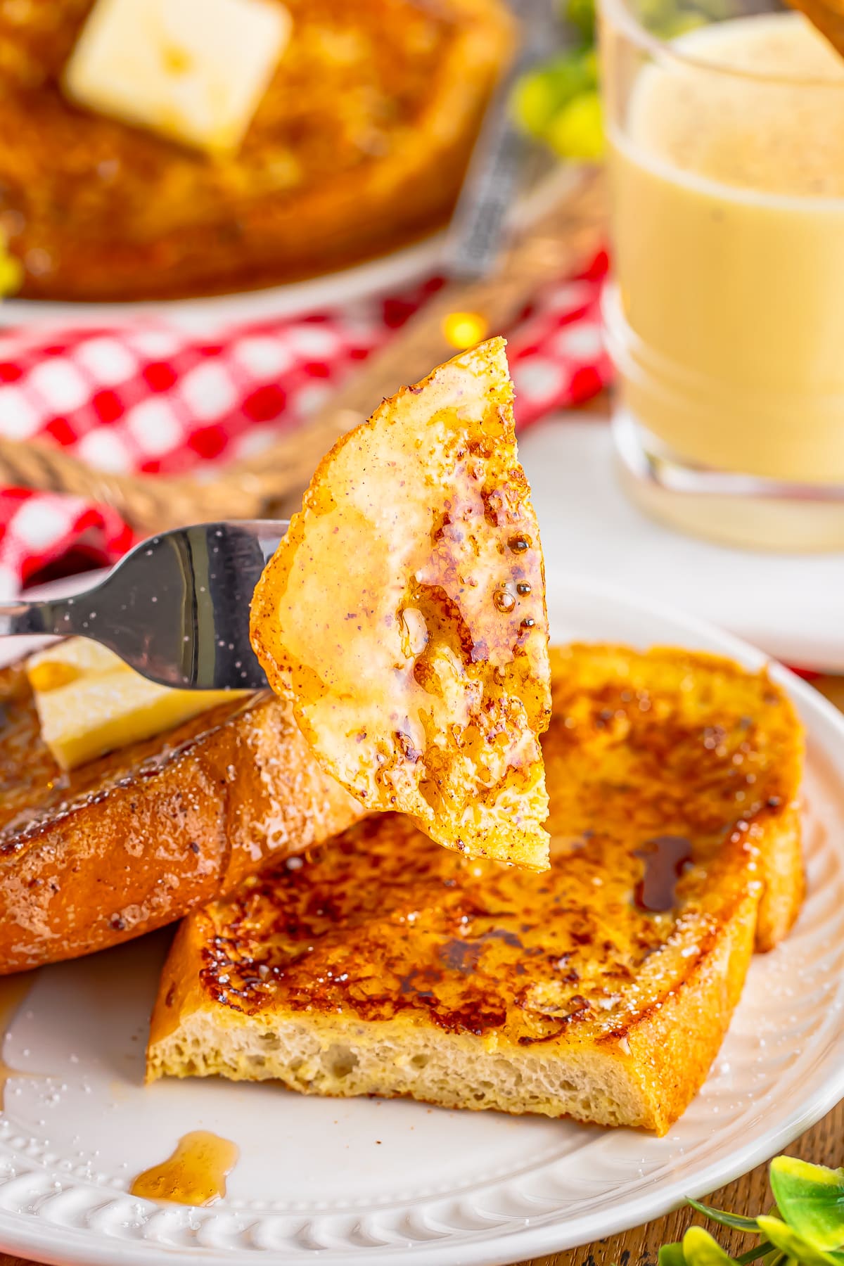 a bite of eggnog french toast on a fork being held up in air