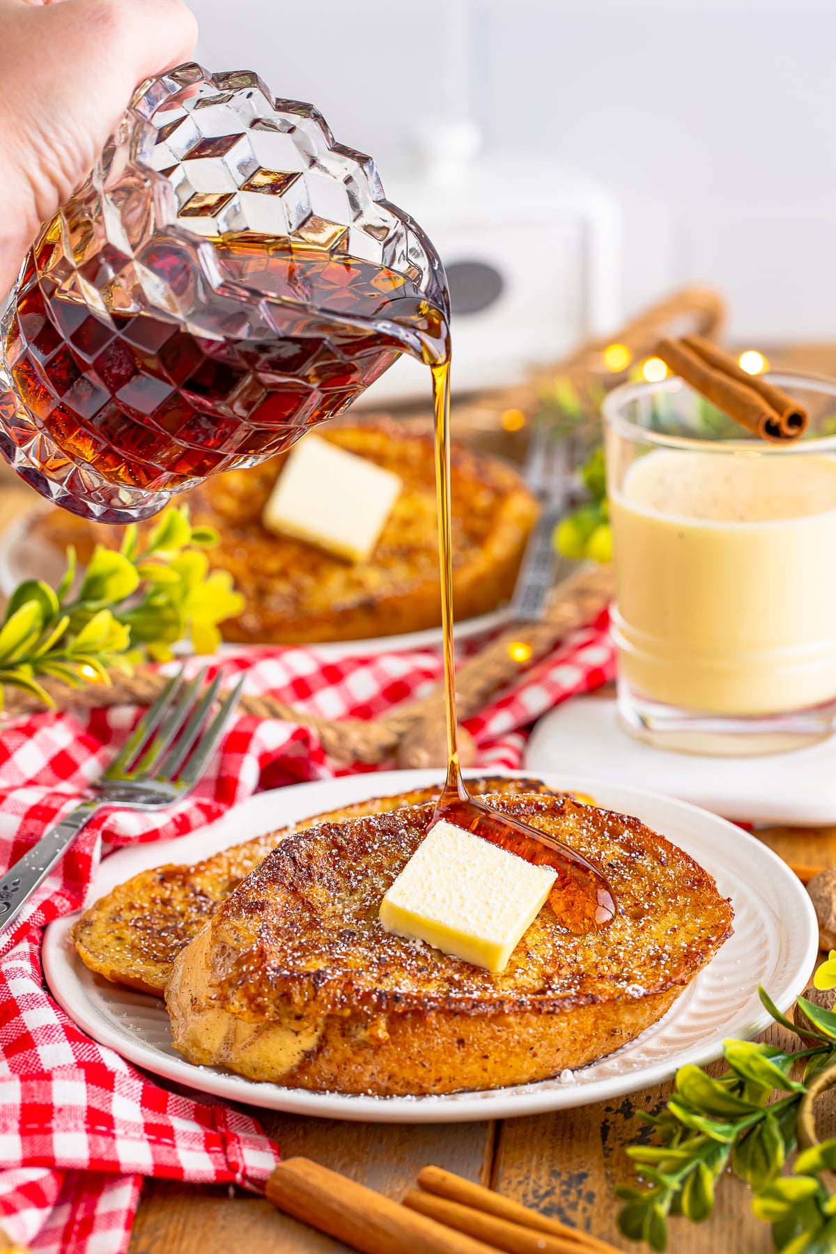 maple syrup being poured on eggnog french toast