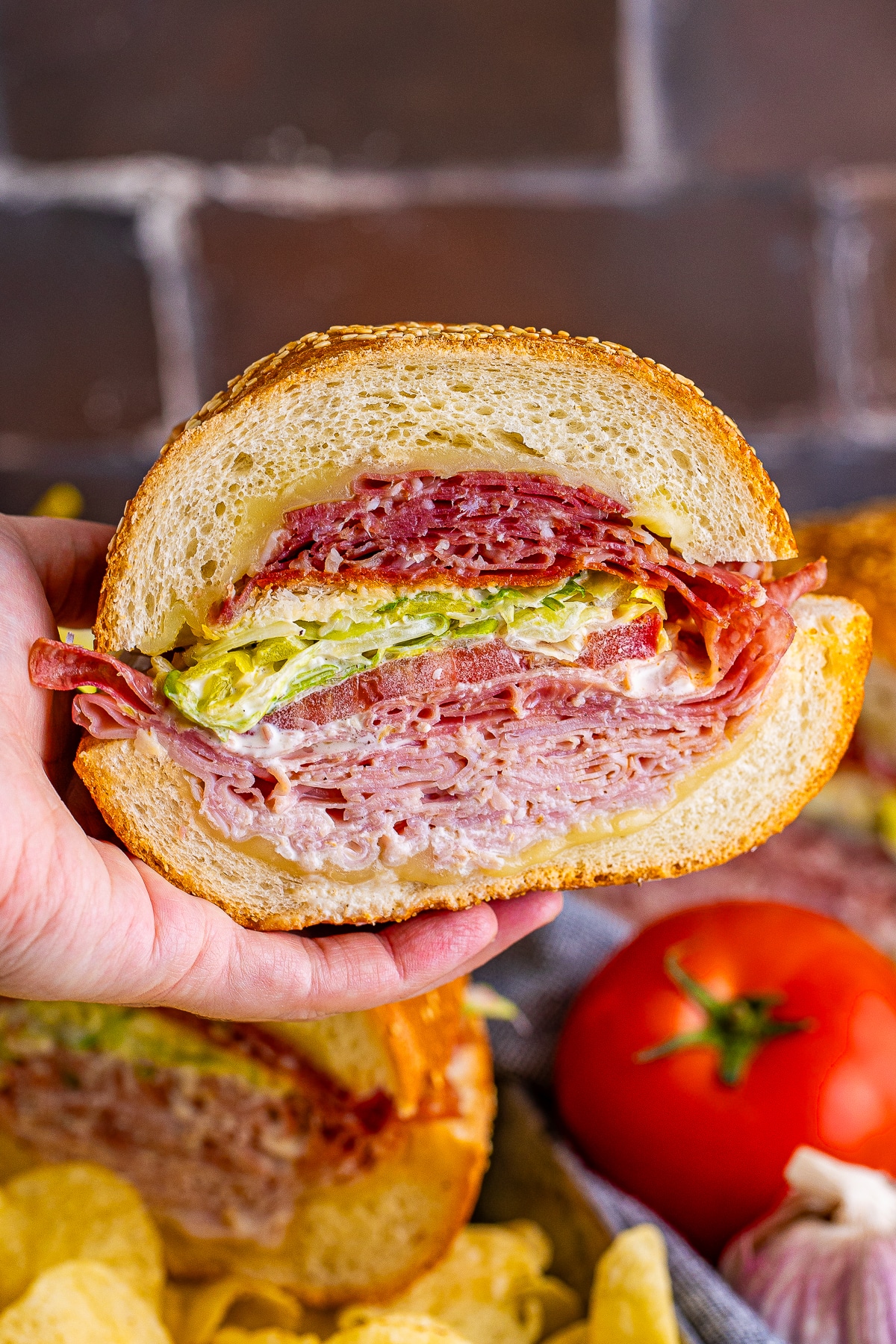 a hand holding up grinder sandwich recipe in air