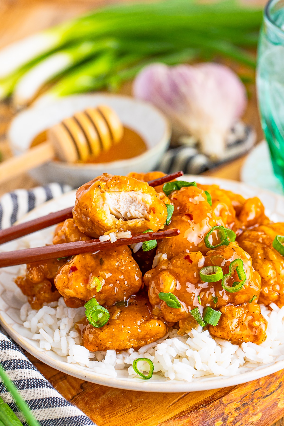 honey garlic chicken recipe with a bite taken out on a plate with chopsticks