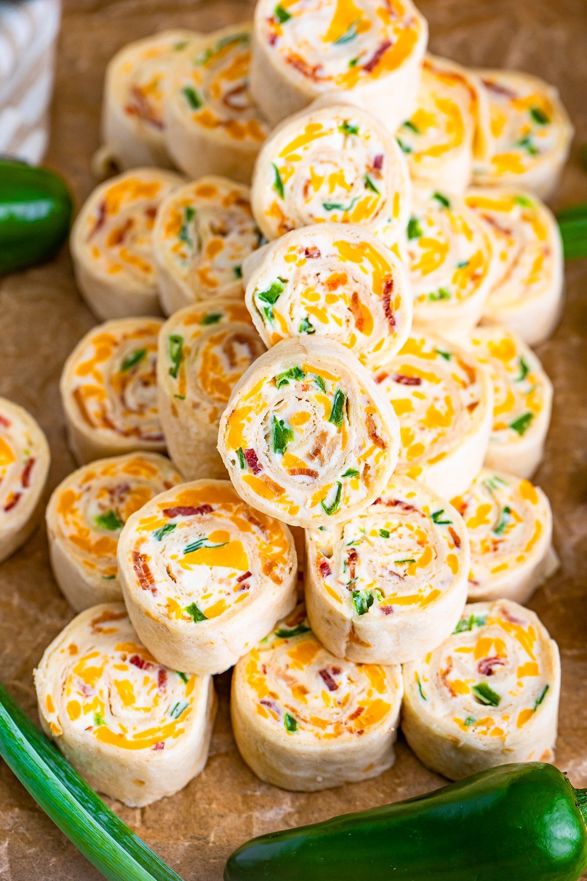 cream cheese pinwheels stacked on parchment paper
