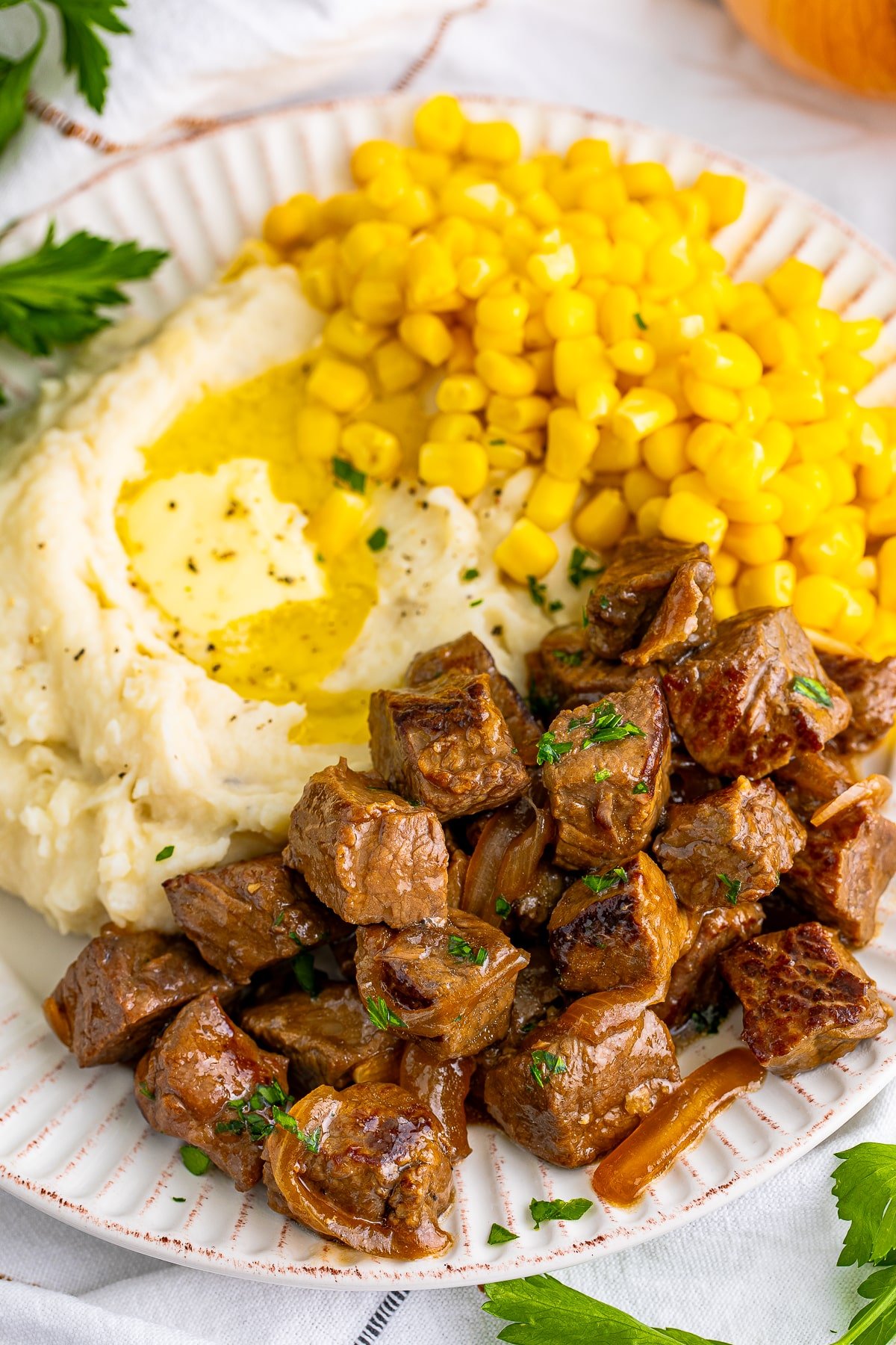 overhead image of slow cooker steak bites on a tan plate