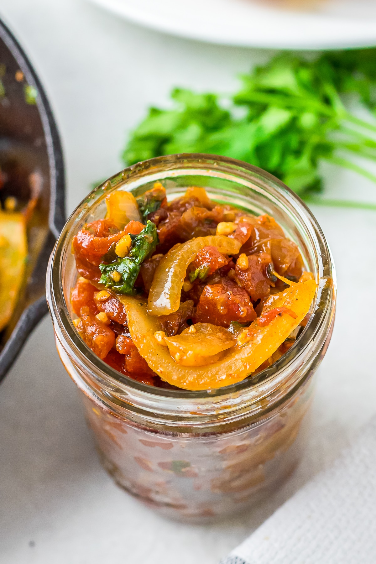 close up tomato onion relish in a glass jar