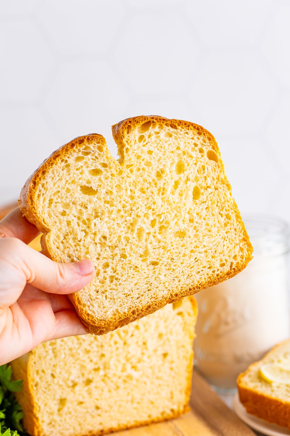 a hand holding up a slice of white bread recipe