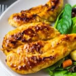Copycat Cracker Barrel Chicken Tenders plated with fresh salad greens, croutons, and lime wedges.