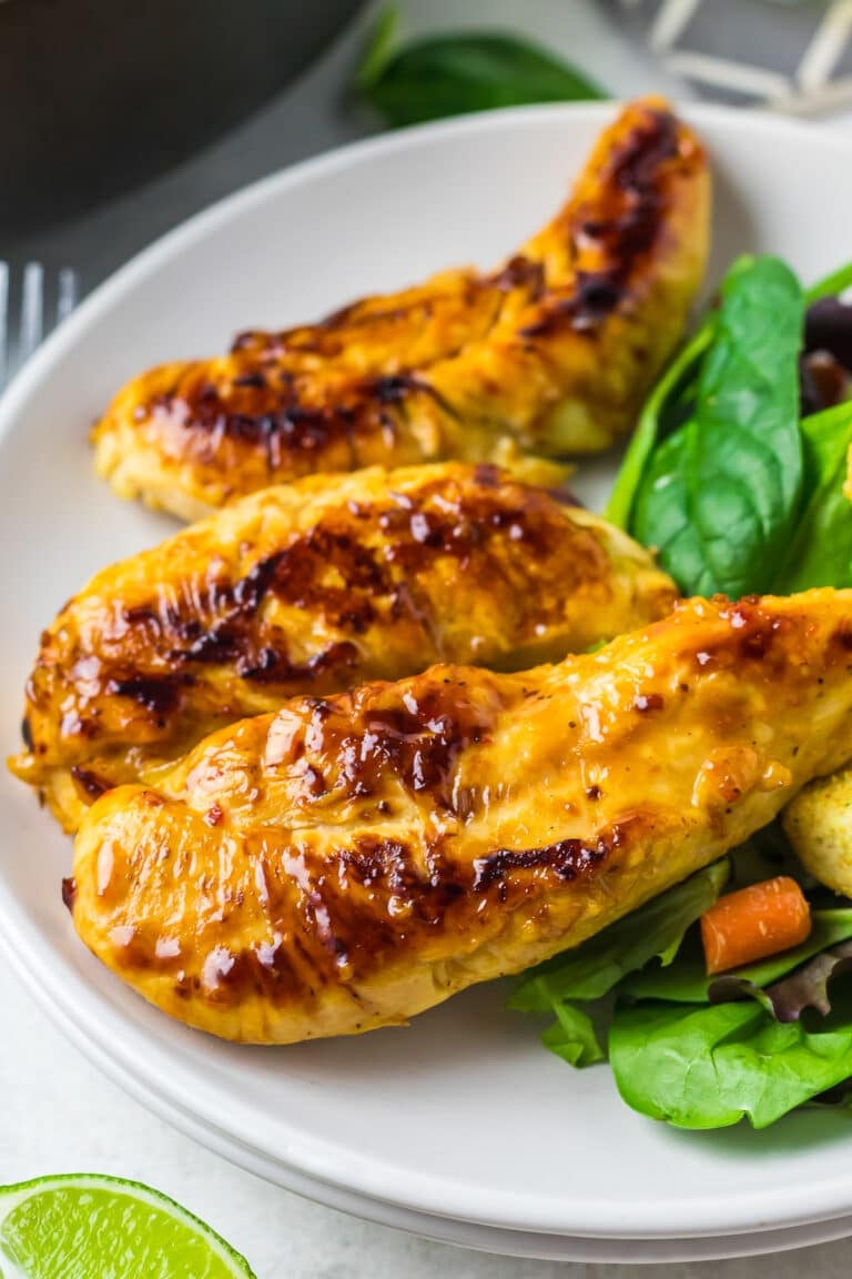 Copycat Cracker Barrel Chicken Tenders plated with fresh salad greens, croutons, and lime wedges.