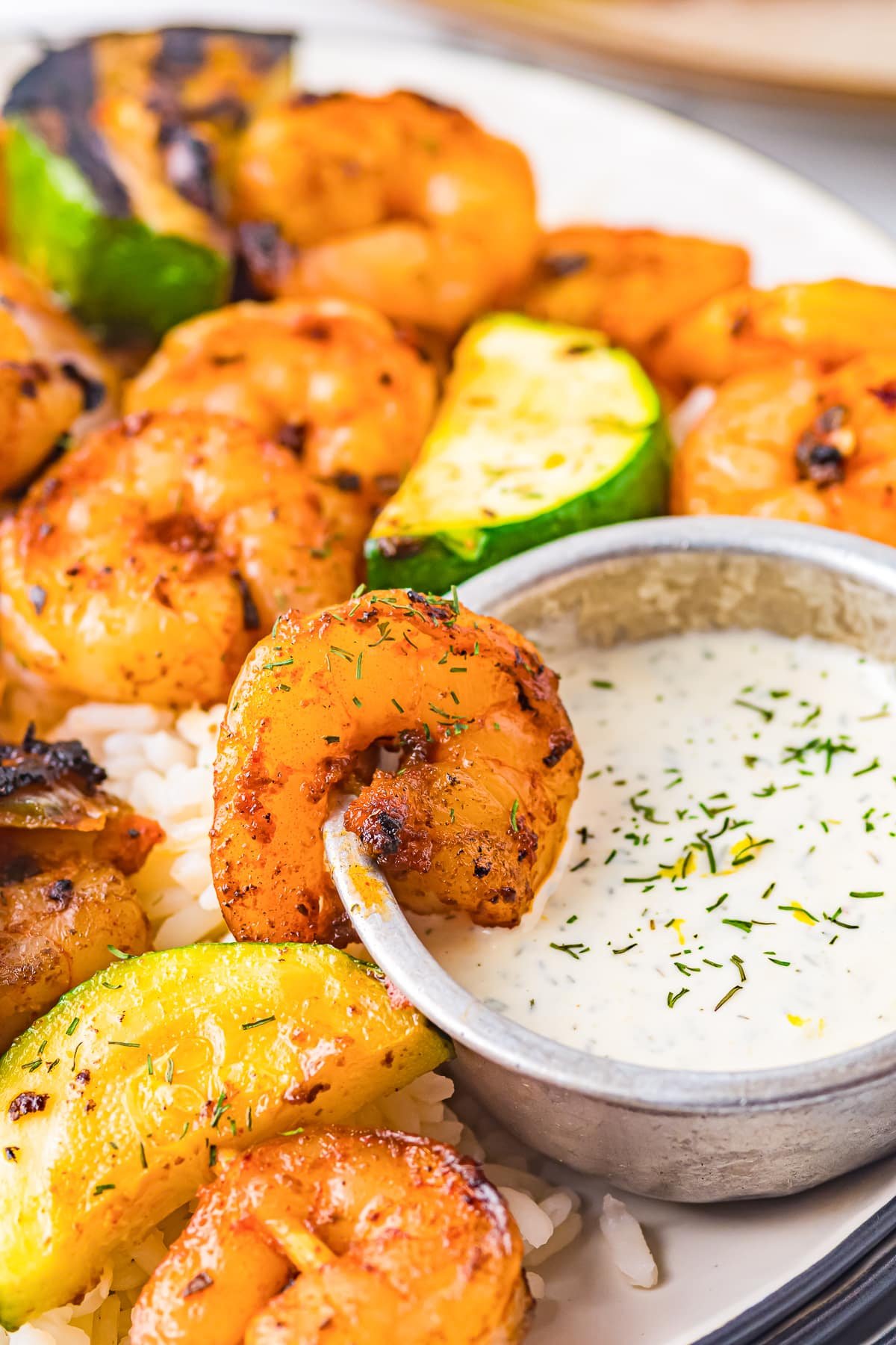 a shrimp from grilled shrimp skewers dipped in dill sauce