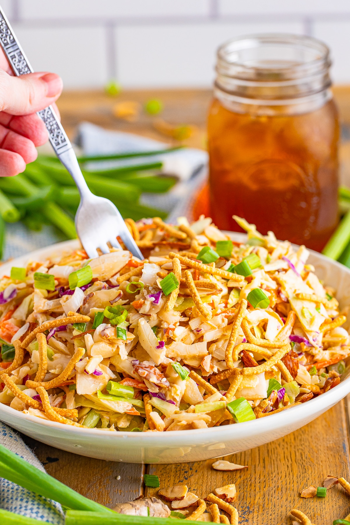 asian slaw recipe in tan bowl with a fork 