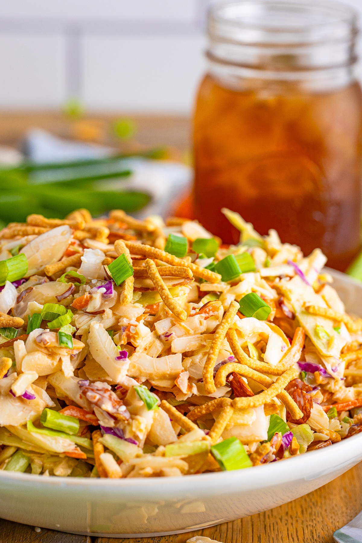upclose image asian slaw recipe in tan bowl with garnishes