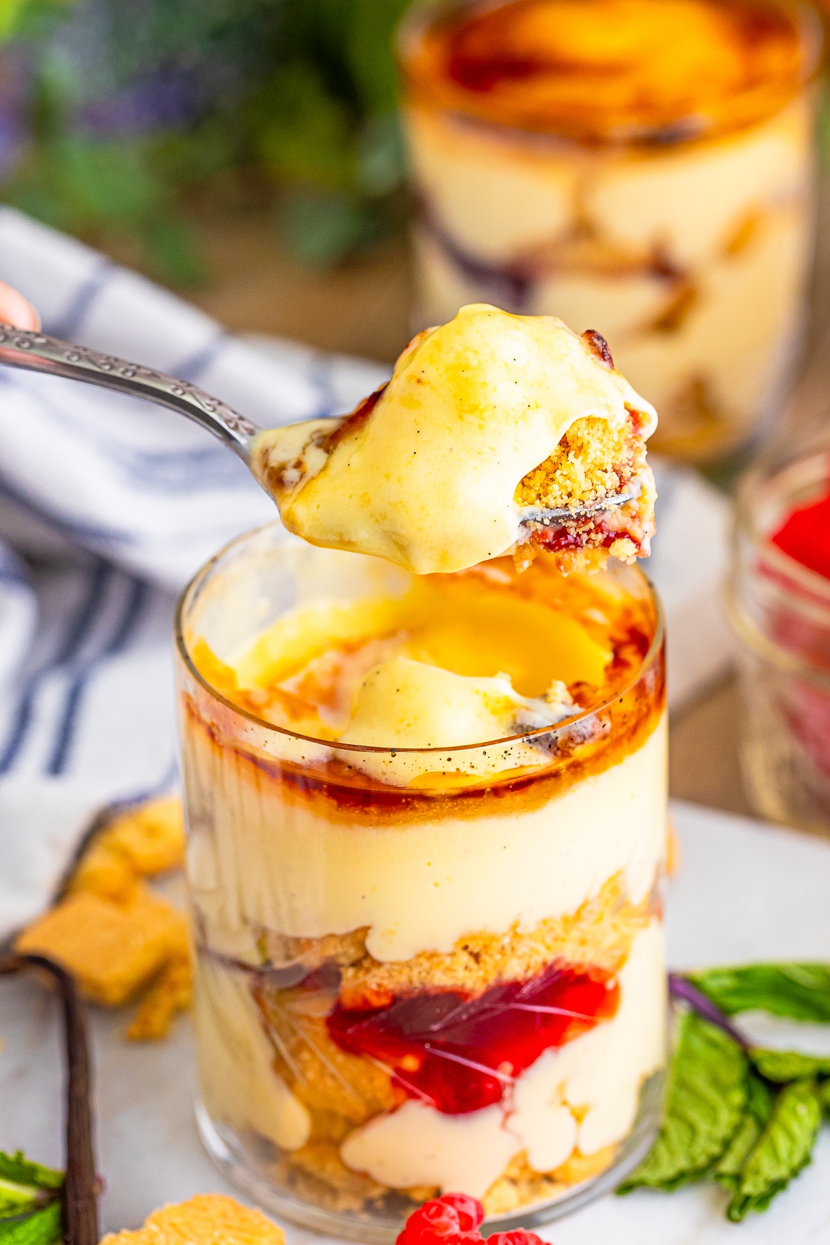 a spoon holding up a bite of mini trifles in air