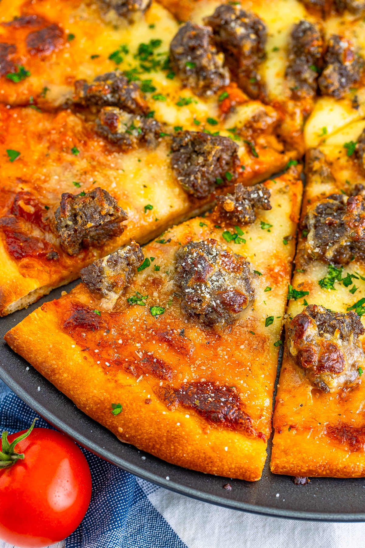 up close image of one slice pizza of meatball pizza
