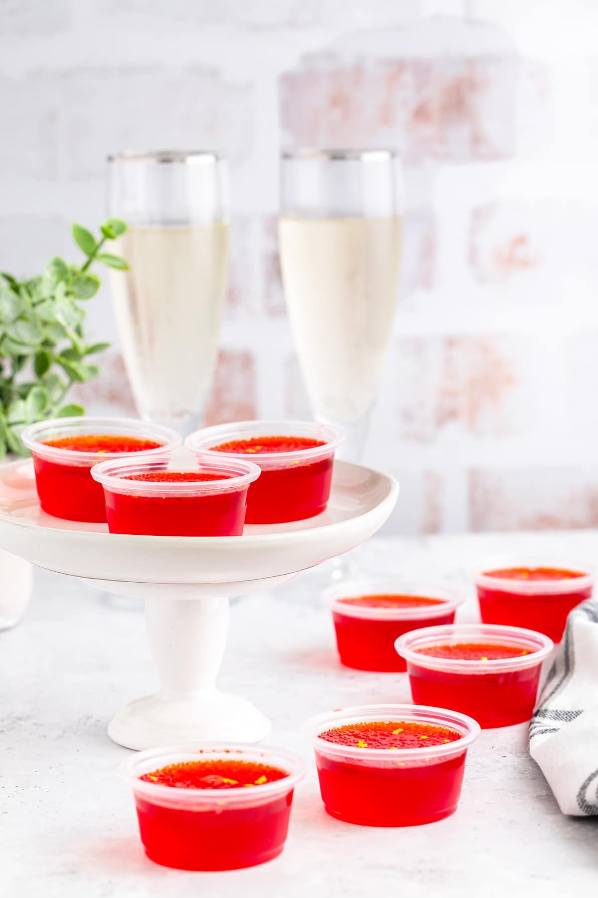 jello shots recipe on a cake stand with champagne glasses
