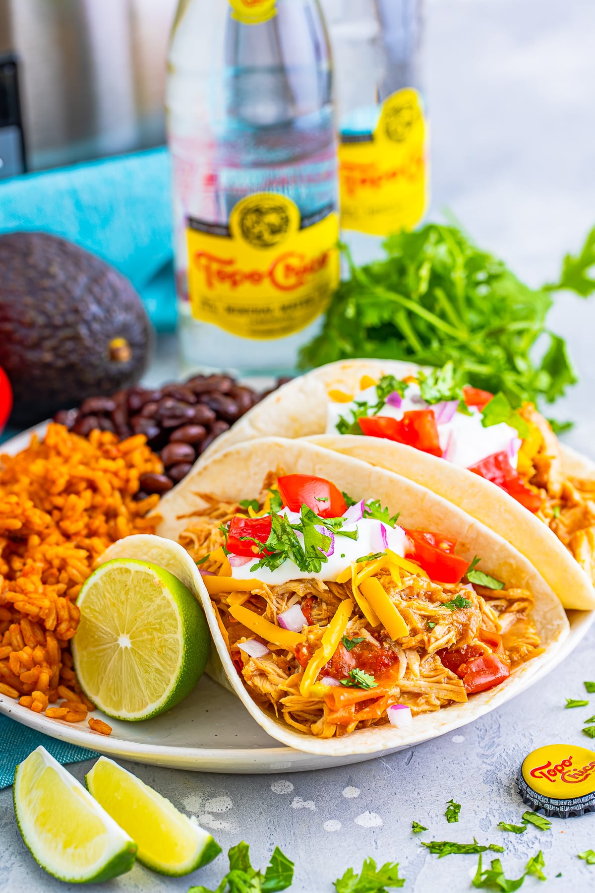 slow cooker mexican shredded chicken tacos on a plate with rice and beans
