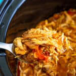 Slow cooker shredded chicken with peppers and onions in the pot, ready to serve.