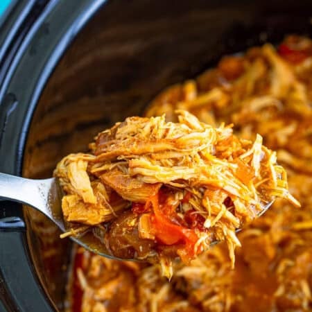 Slow cooker shredded chicken with peppers and onions in the pot, ready to serve.