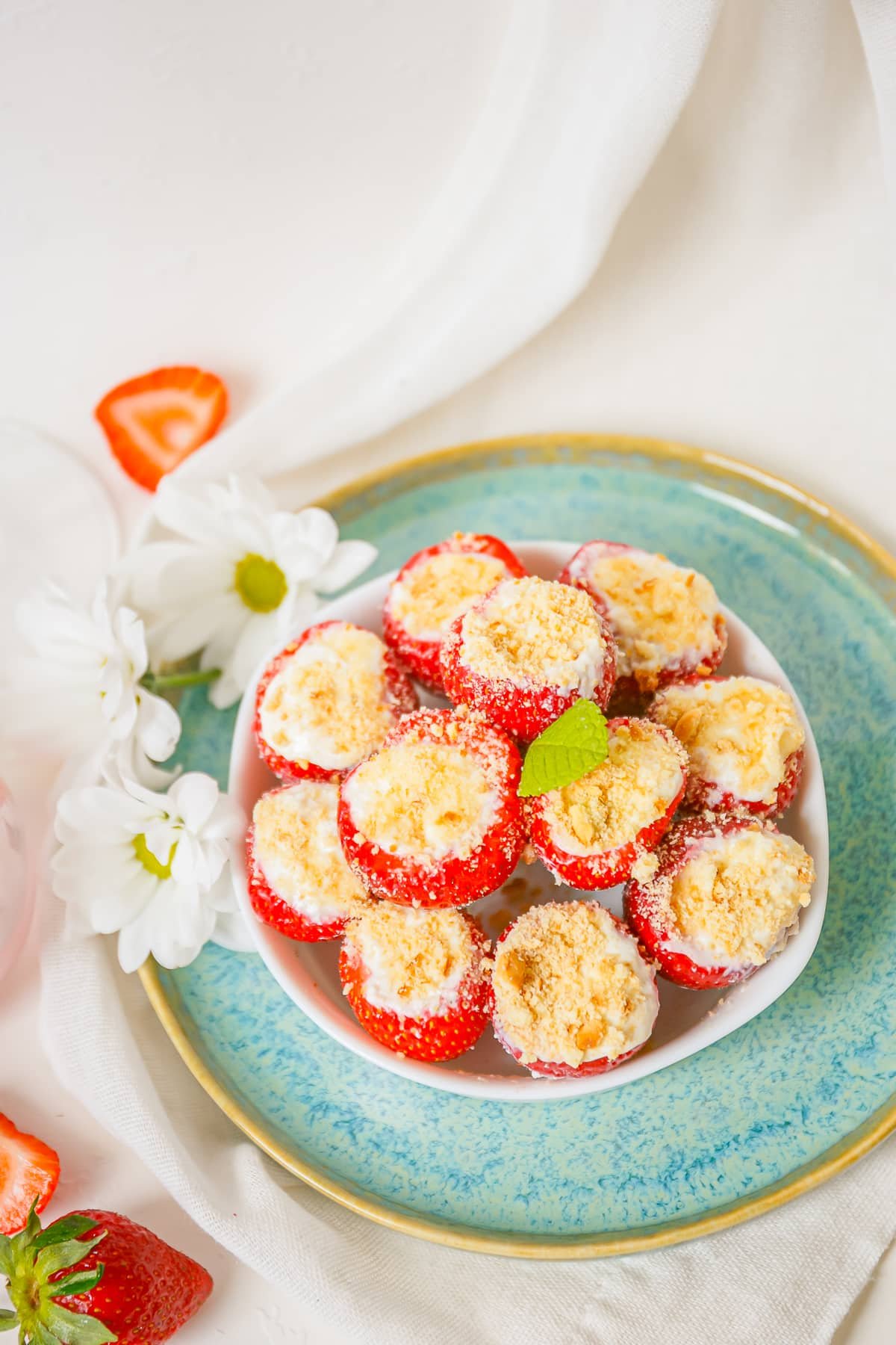Cheesecake Stuffed Strawberries in a serving bowl on a blue plate