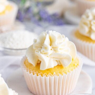 A white wedding cake cupcake with a swirl of almond buttercream on top.