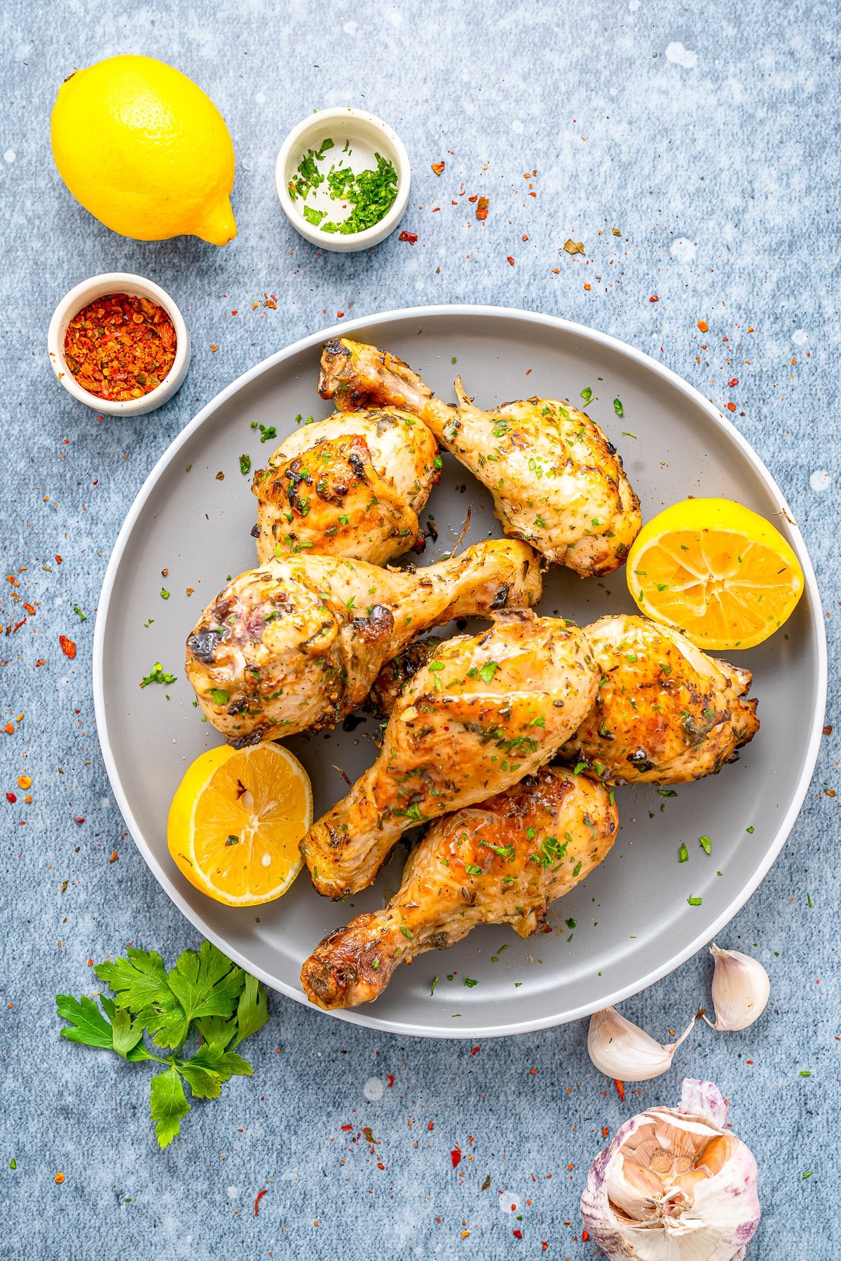 overhead image of Air Fryer Chicken Legs on a grey serving platter with lemons