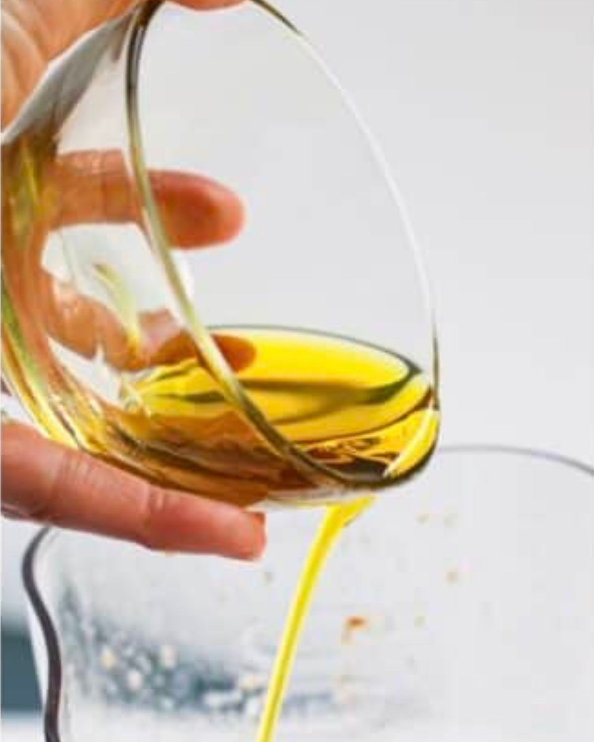 olive oil being poured in a blender jar.