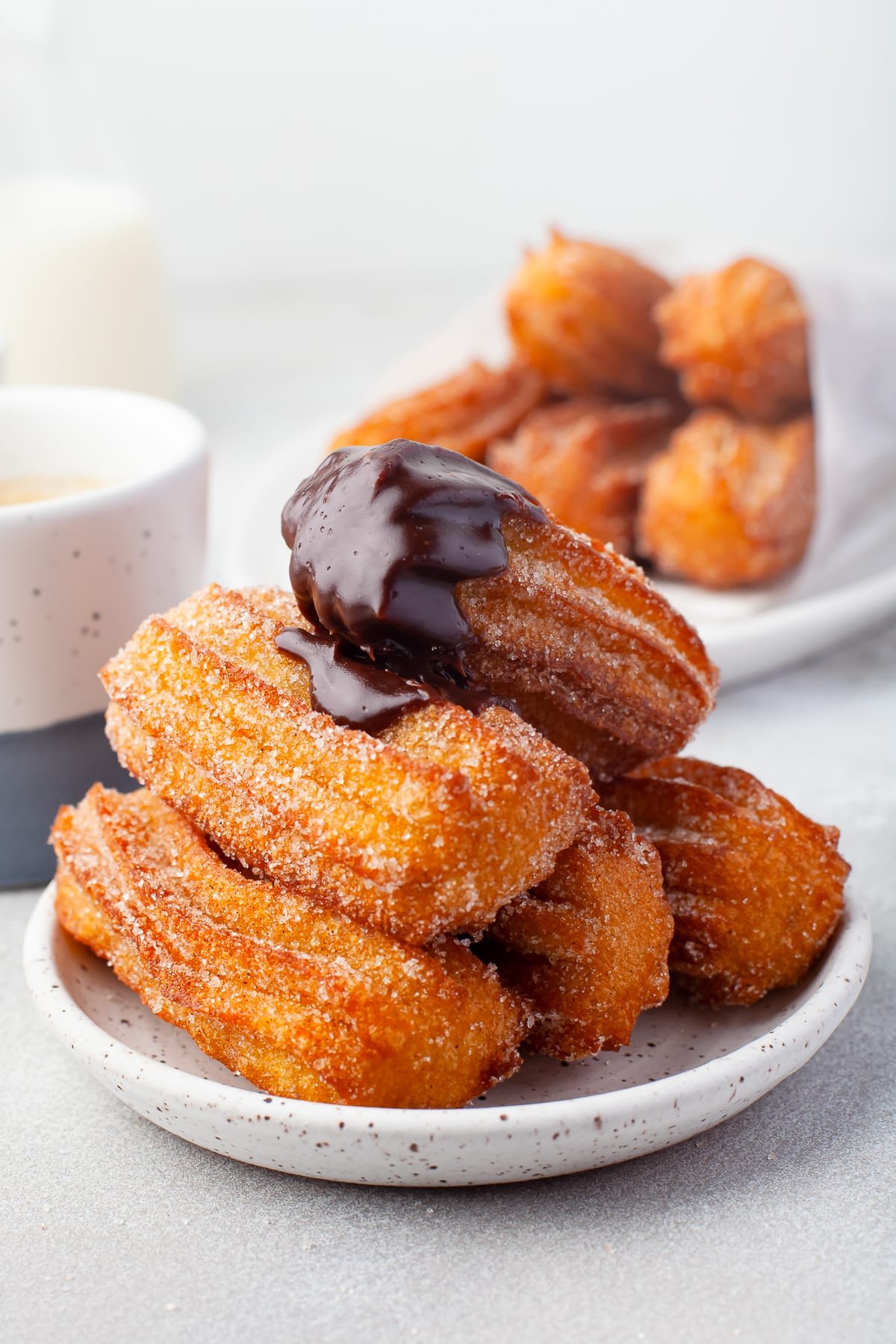 mini churros stacked and dipped in chocolate