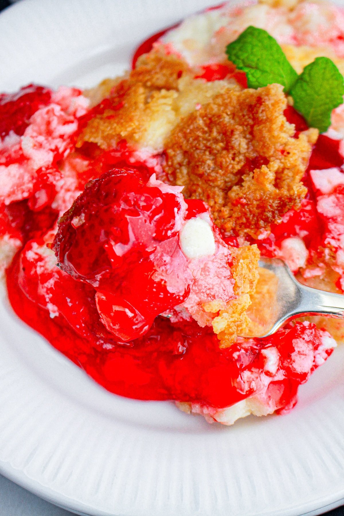 a fork scooping out a bite of Strawberry Dump Cake